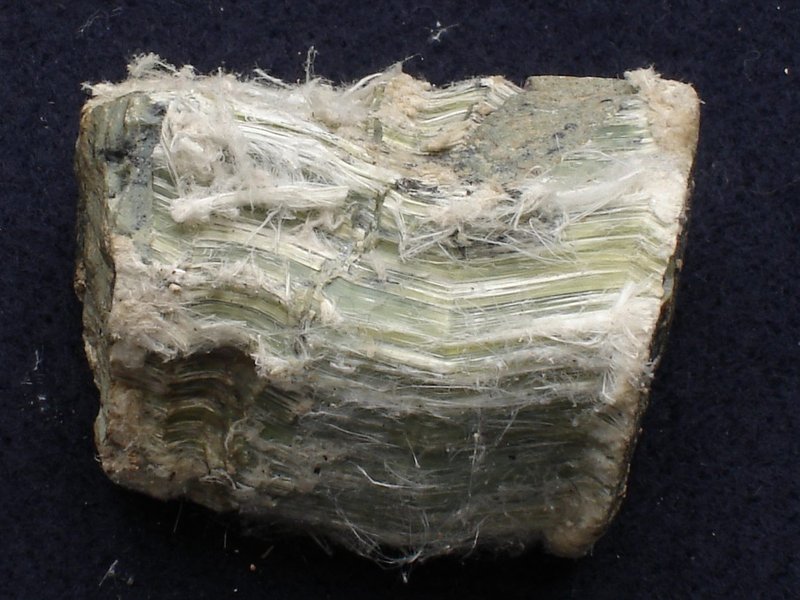 Chrysotile (white asbestos) mineral specimen showing curly white silky fibres